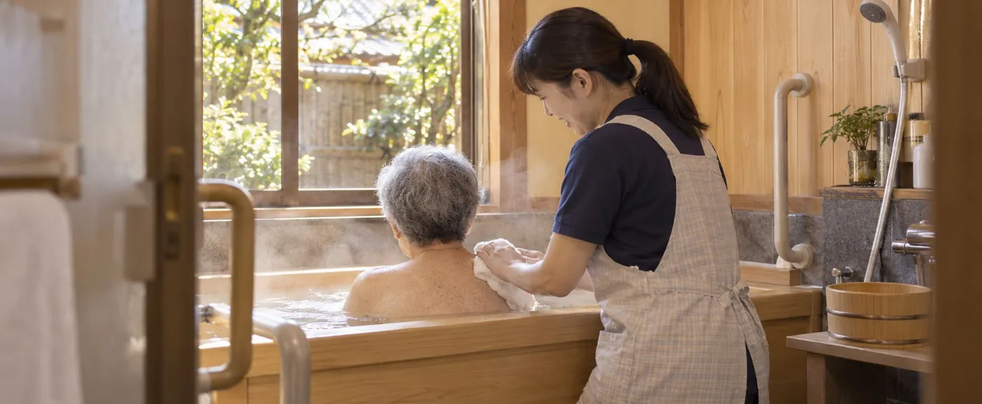 個室の浴室で入浴を介助する様子